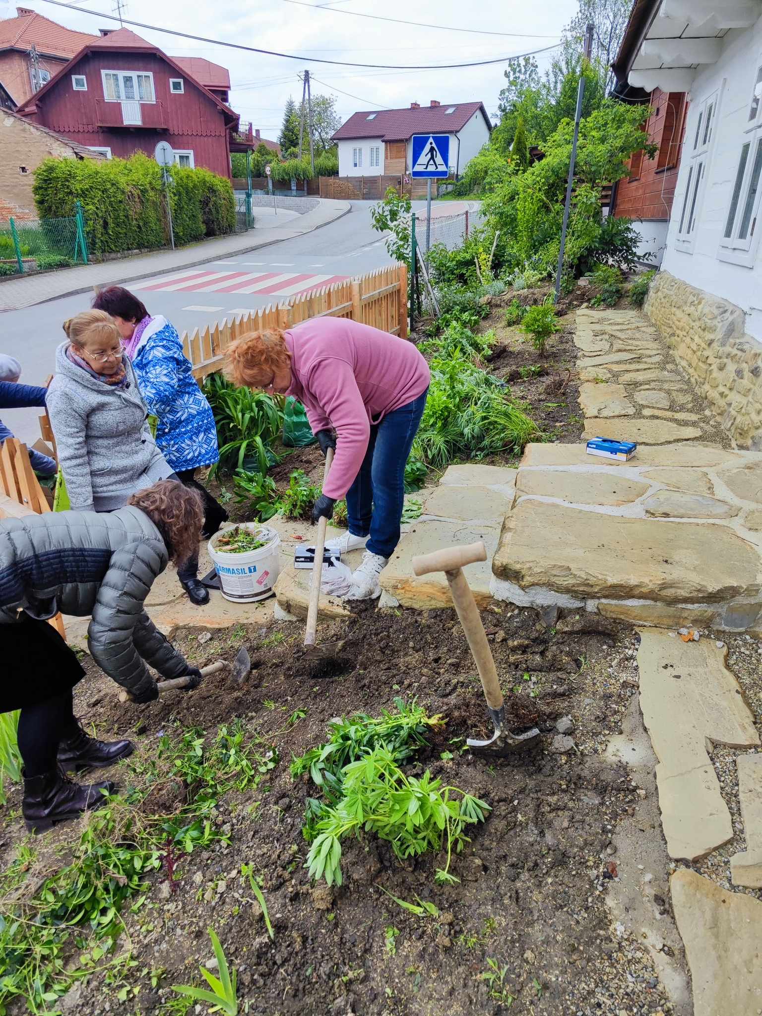 Sadzenie tradycyjnych kwiatów przez seniorów z Klubu Seniora przyzabytkowym budynku „Szpitalka” w Dębowcu